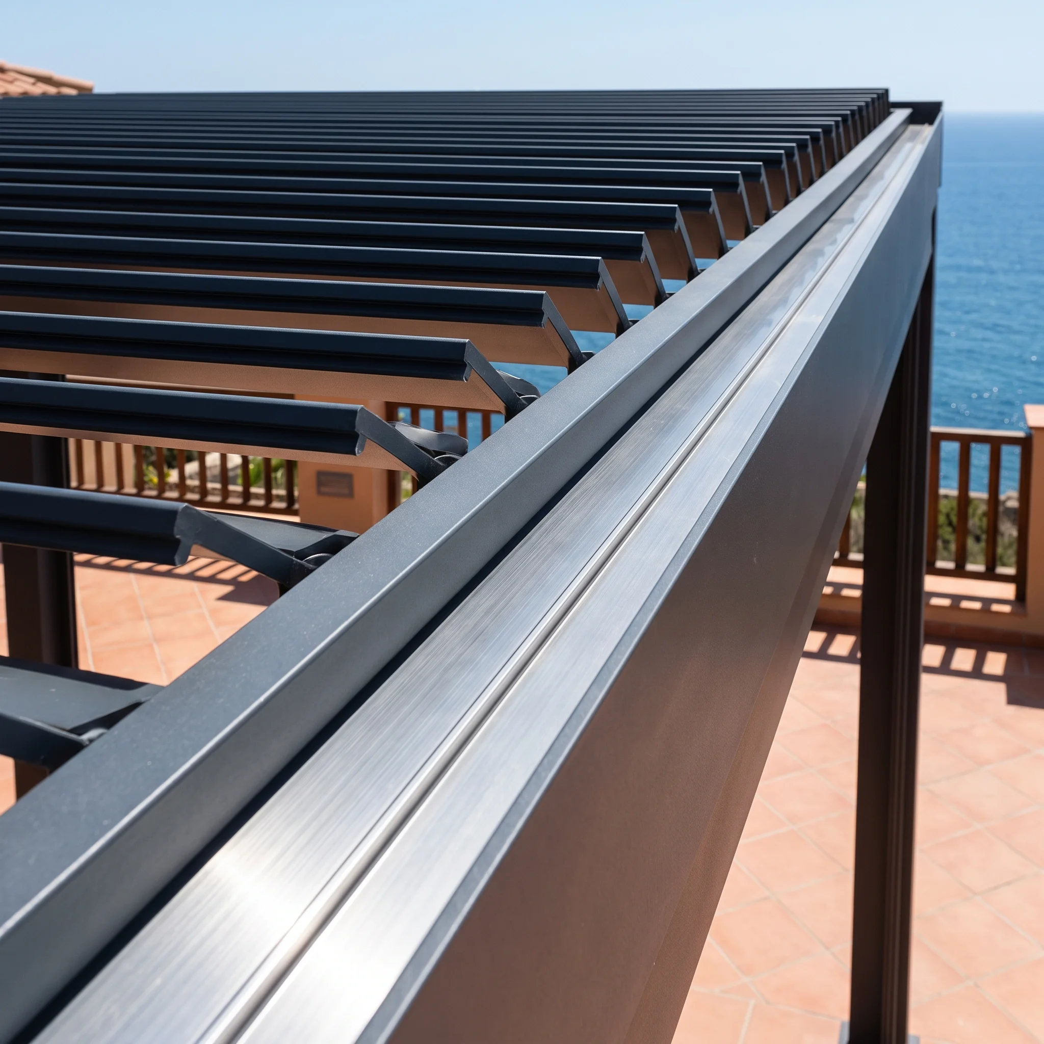 Close-up of a louvered pergola roof's aluminum blade hinge and motor mechanism, engineered for coastal wind exposure